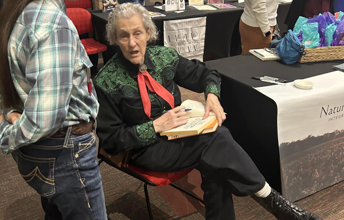 Author-speaker and animal-science visionary Temple Grandin signs copies of her book "The Way I See It" after speaking at Jonesboro conference