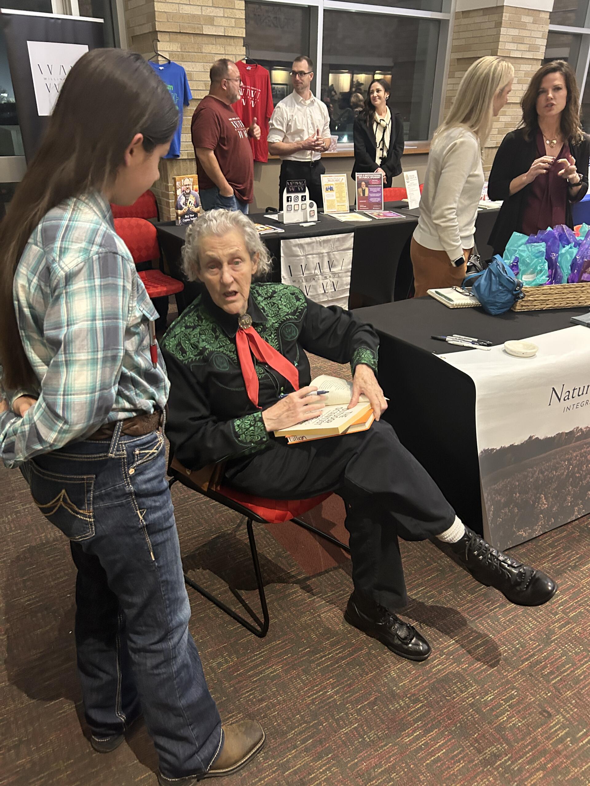 Author-speaker and animal-science visionary Temple Grandin signs copies of her book "The Way I See It" after speaking at Jonesboro conference