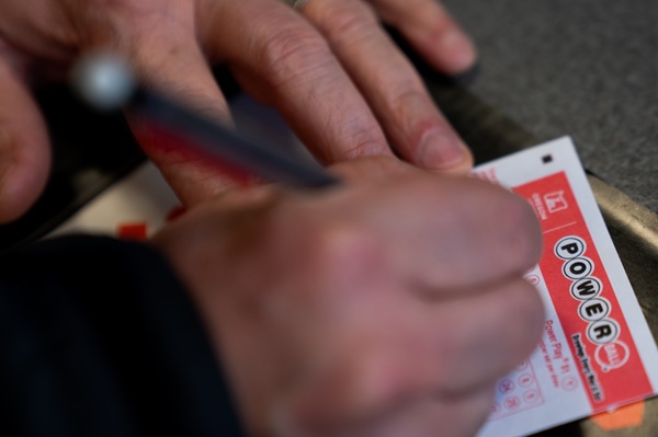 A person fills out a Powerball lottery ticket on Monday, Dec. 22, 2025, in Portland, Ore. (AP Photo/Jenny Kane)