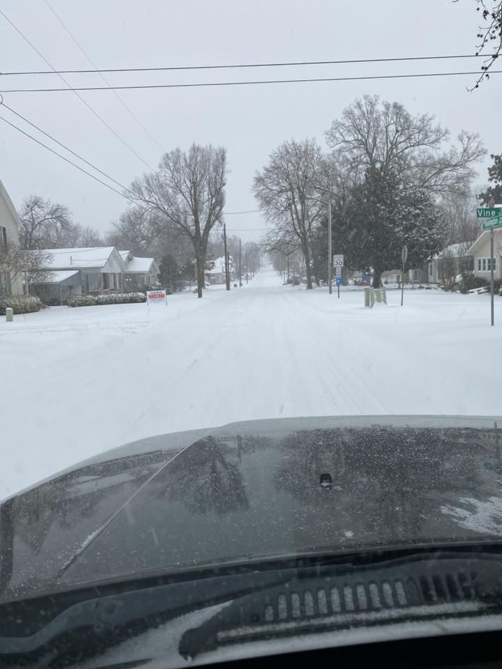 Snow covered street and hood of car
