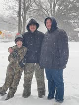 Three people standing in snow