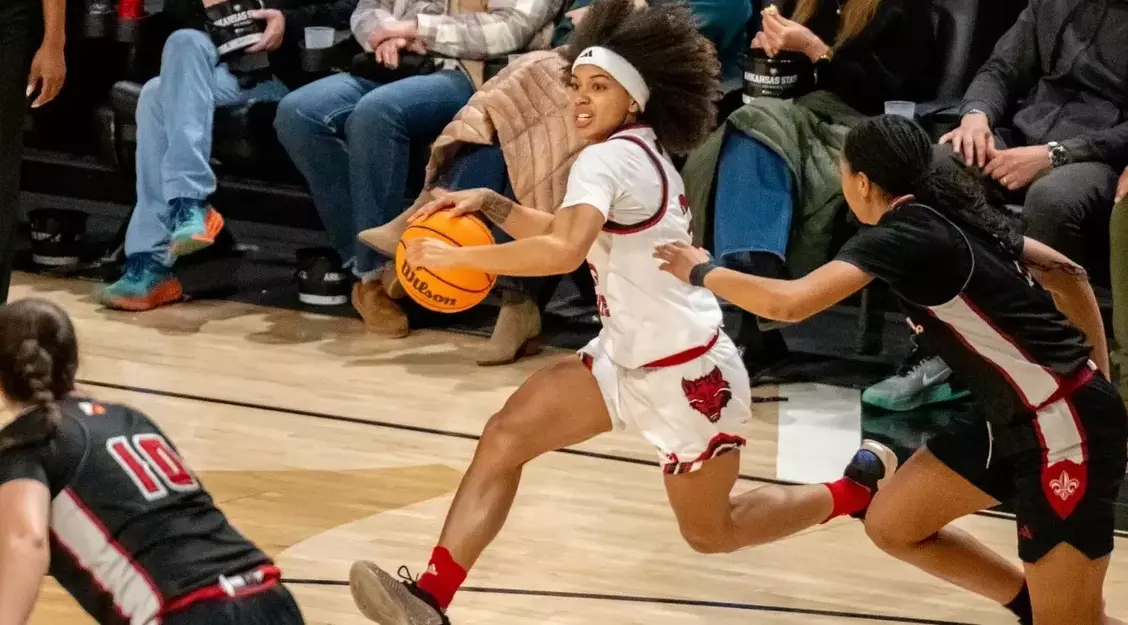 female basketball player action shot with white Arkansas State uniform