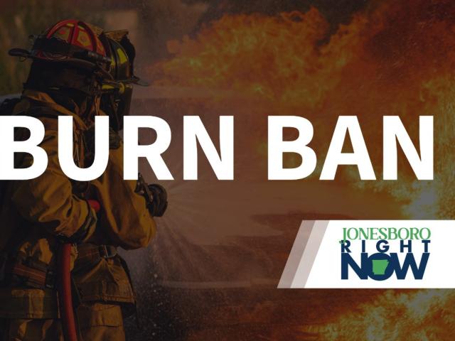 image of fireman putting out fire with Burn Ban in foreground