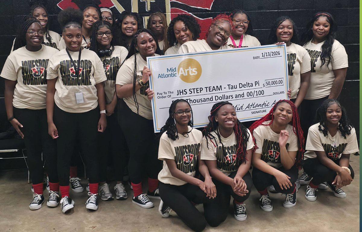 group of young women holding check presented to JHS step team
