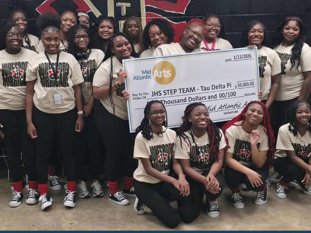 group of young women holding check presented to JHS step team
