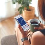 woman holds cell phone with financial information on it