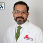 professional image of man in lab coat with glasses and beard. The lab coat says St Bernards medical center