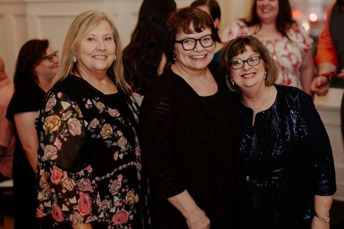 three women pose together
