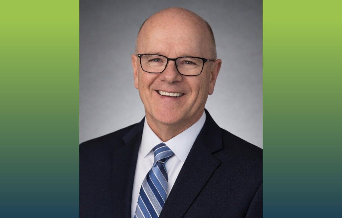 head shot of a man with blue suit and blue striped tie