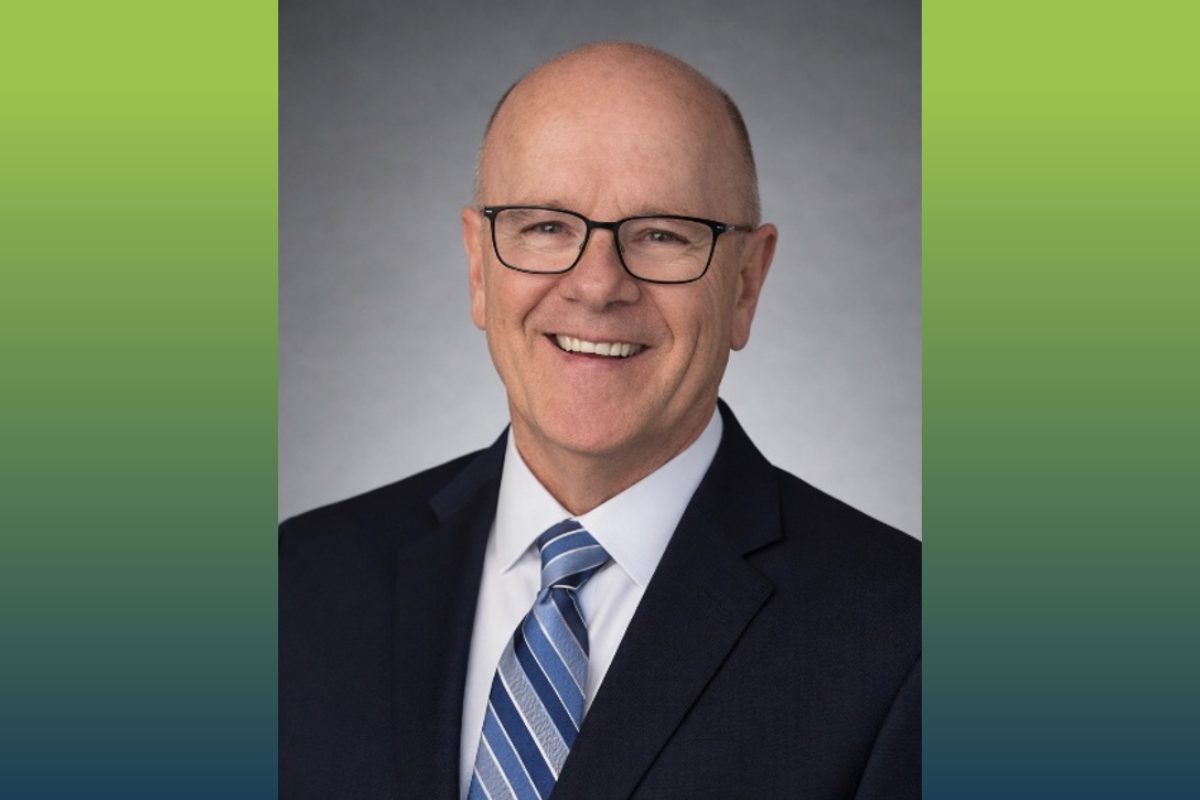 head shot of a man with blue suit and blue striped tie