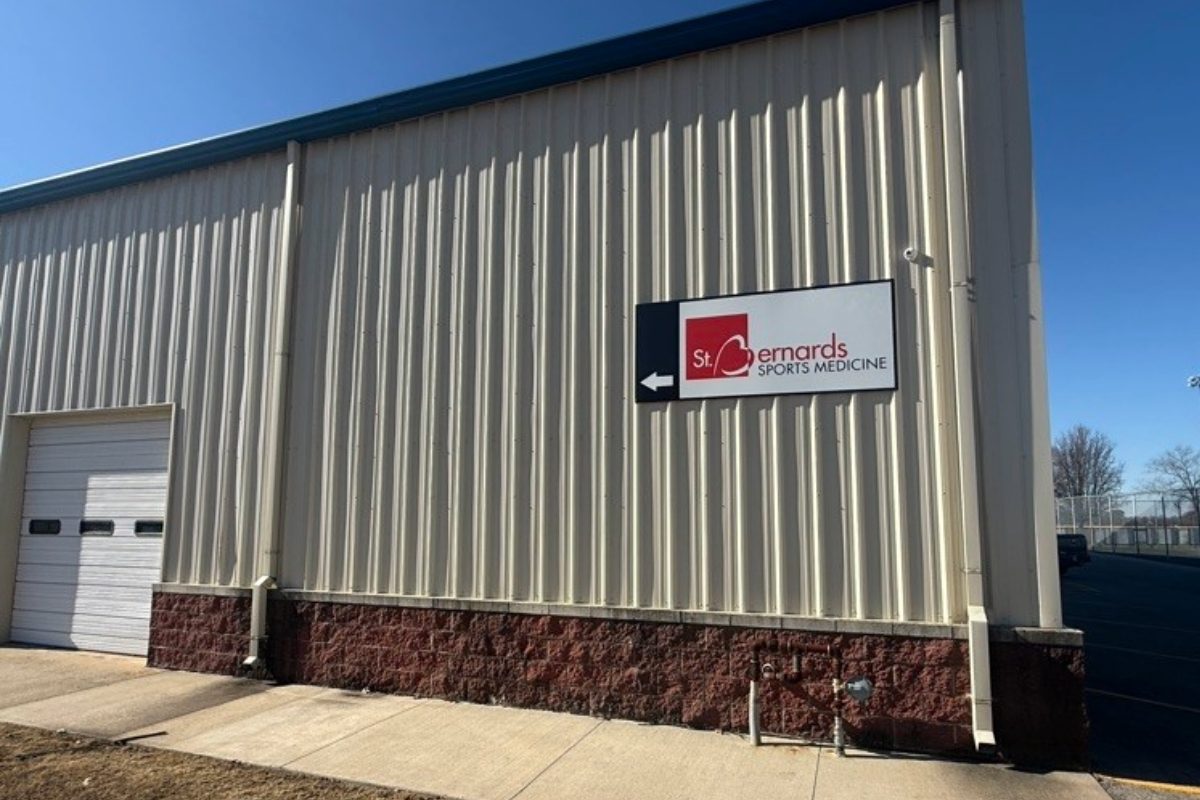 Tan building with brick base and sign that says St Bernards Sports Clinic
