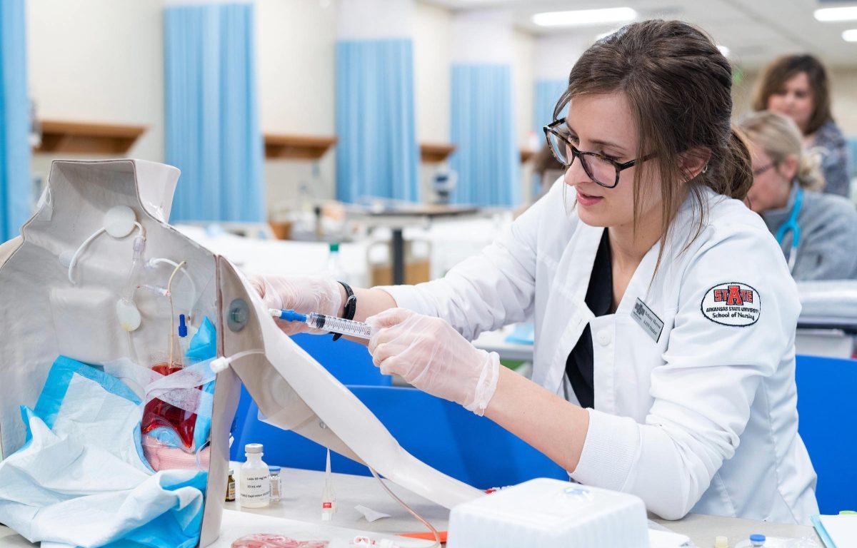 An A-State nursing student practices hands-on clinical skills during a simulation lab exercise.