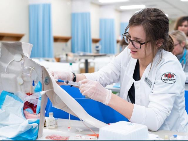An A-State nursing student practices hands-on clinical skills during a simulation lab exercise.