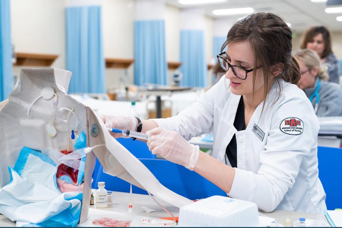 An A-State nursing student practices hands-on clinical skills during a simulation lab exercise.
