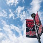 A-State flag on blue sky with clouds