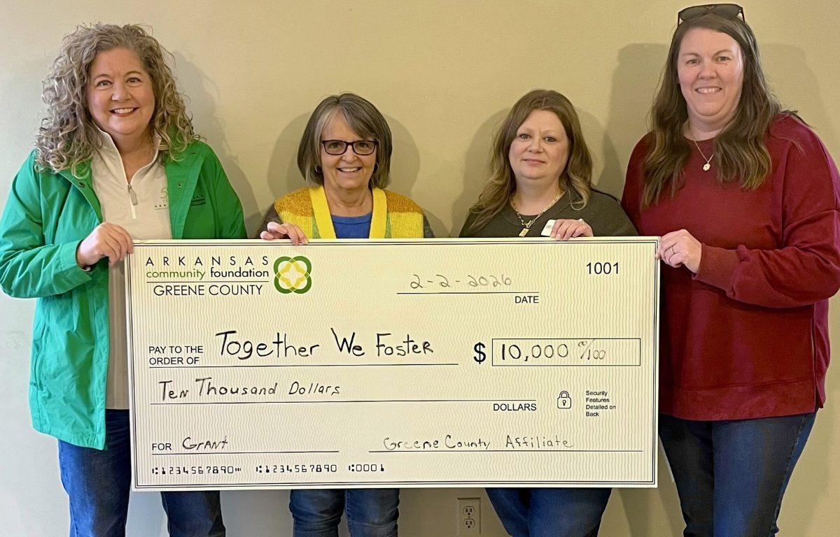 four women hold check for $10,000
