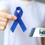 man holding dark blue ribbon for colorectal cancer