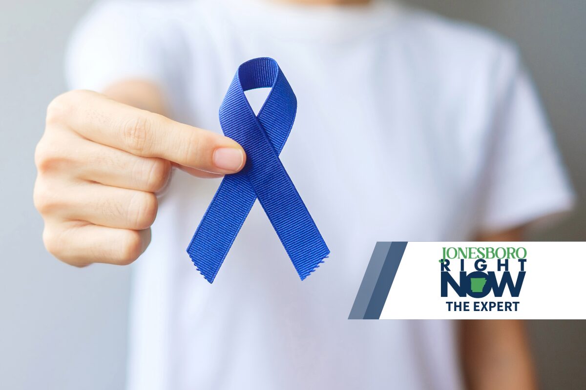 man holding dark blue ribbon for colorectal cancer