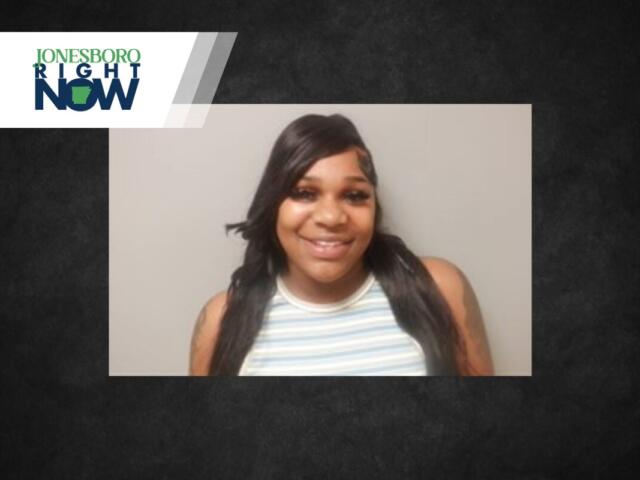 Smiling woman with long dark hair in a striped sleeveless top, head-and-shoulders portrait against a gray backdrop, with a Jonesboro Right Now banner in the corner.
