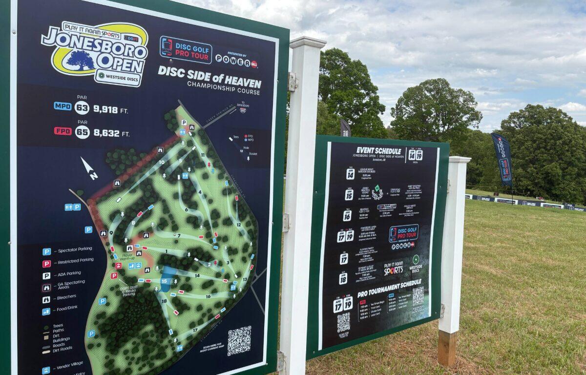 Signboard at a disc golf course showing the Jonesboro Open map and 'Disc Side of Heaven' championship course information.