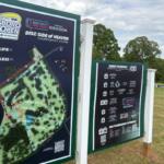 Signboard at a disc golf course showing the Jonesboro Open map and 'Disc Side of Heaven' championship course information.