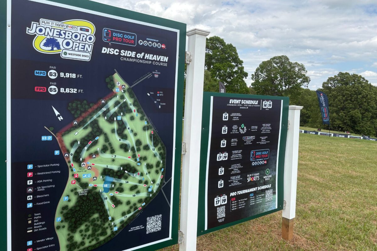 Signboard at a disc golf course showing the Jonesboro Open map and 'Disc Side of Heaven' championship course information.
