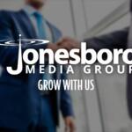 Two men shaking hands with logo in foreground