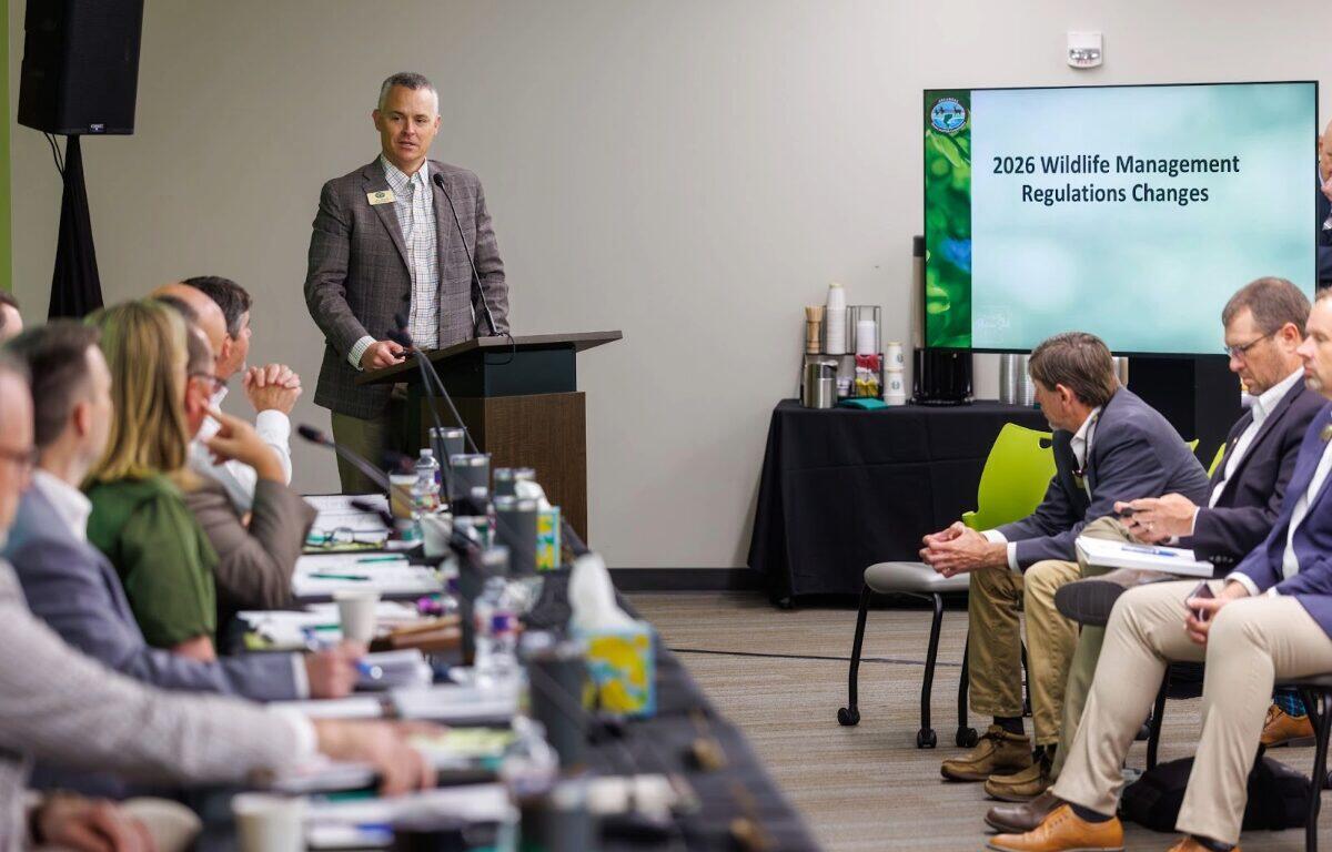 man in gray suit presents before room of people
