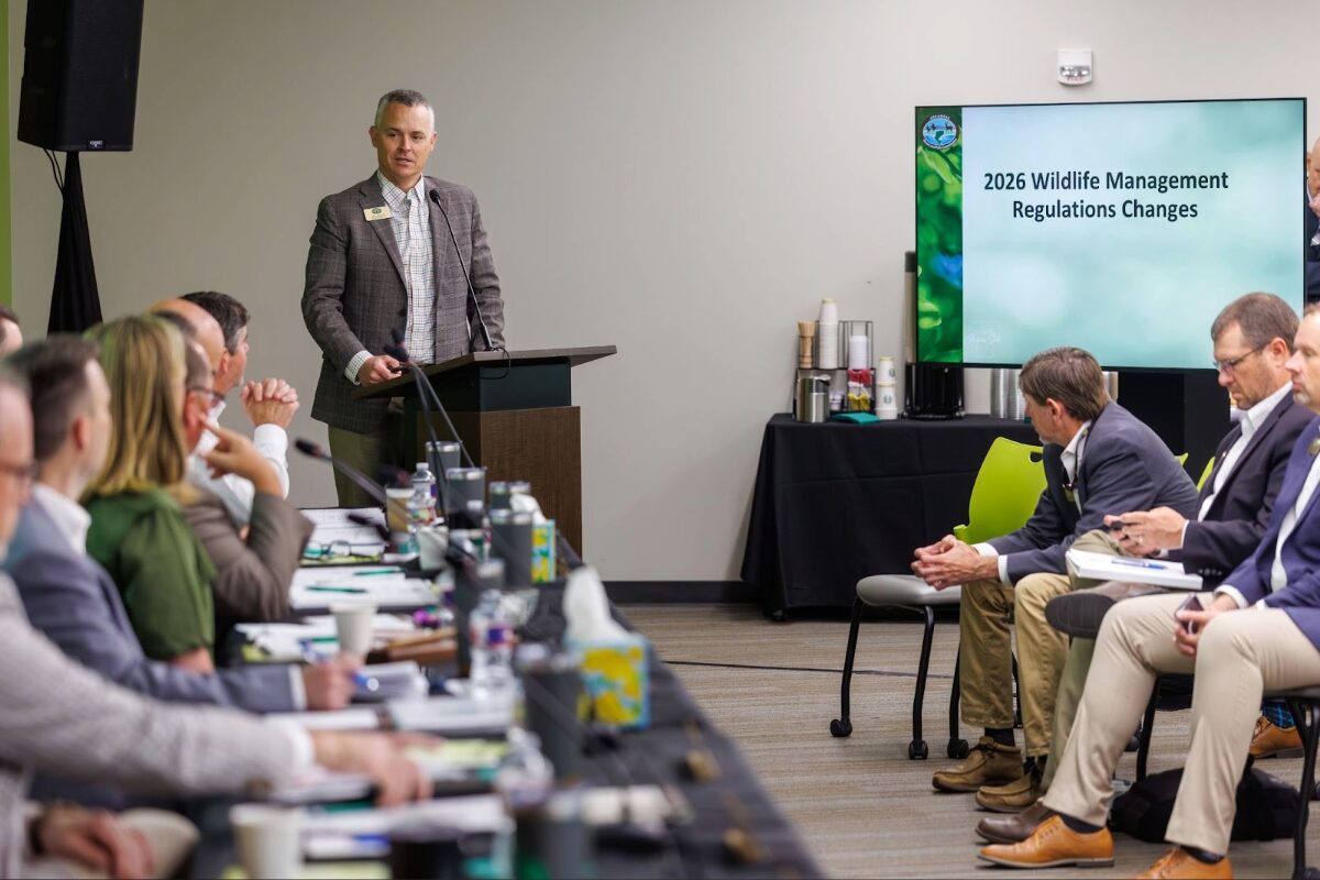 man in gray suit presents before room of people