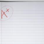 Red pen annotation on a spiral notebook page: letters 'A' and 'X' circled in red ink.