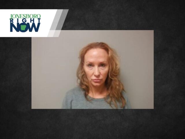 Mugshot-style photo of a woman with wavy blonde hair wearing a gray top and a neutral expression against a plain wall, with Jonesboro Right Now branding in the corner.