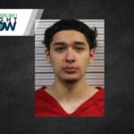 Mugshot of a young man with dark hair wearing a red shirt, posed against a measurement background; Jonesboro Right Now logo in the top-left corner.