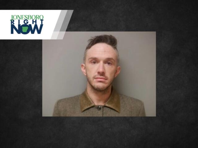 Mugshot-style portrait of a man in a brown coat with a neutral expression, against a gray background, with a Jonesboro Night Now logo banner in the corner.