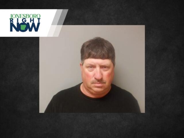 Mugshot-style photo of a middle-aged man in a black shirt, neutral gray backdrop, with a Jonesboro Right Now news banner in the top-left corner