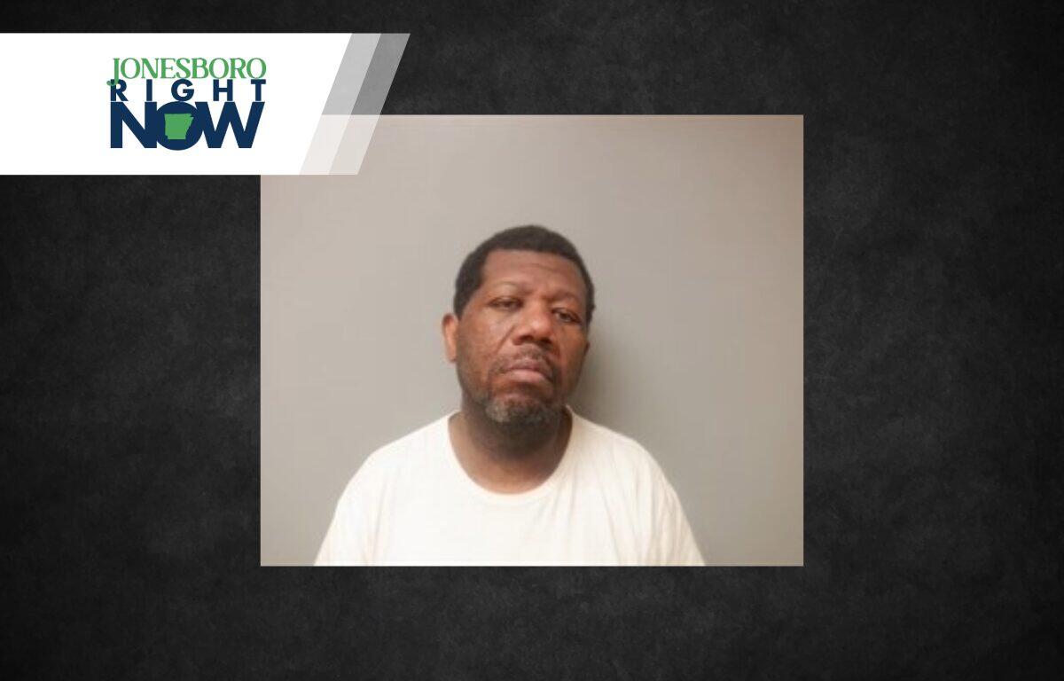 Mugshot-style photo of a man in a white T-shirt against a gray wall, used in a Jonesboro Right Now news banner.
