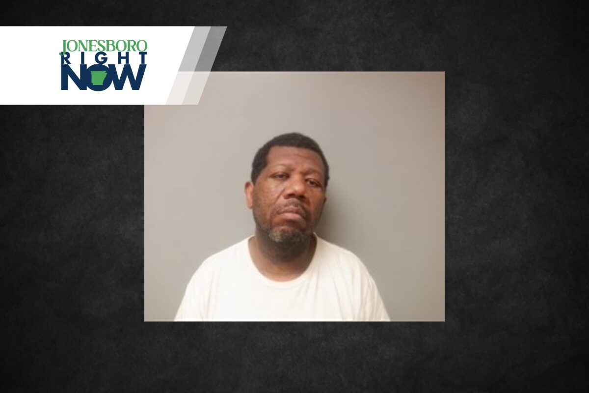 Mugshot-style photo of a man in a white T-shirt against a gray wall, used in a Jonesboro Right Now news banner.
