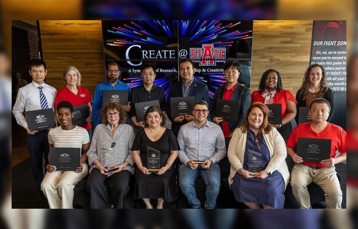 Group of diverse people posing with awards/plaques at a ceremony, banner reads 'Create @ State' in the background.
