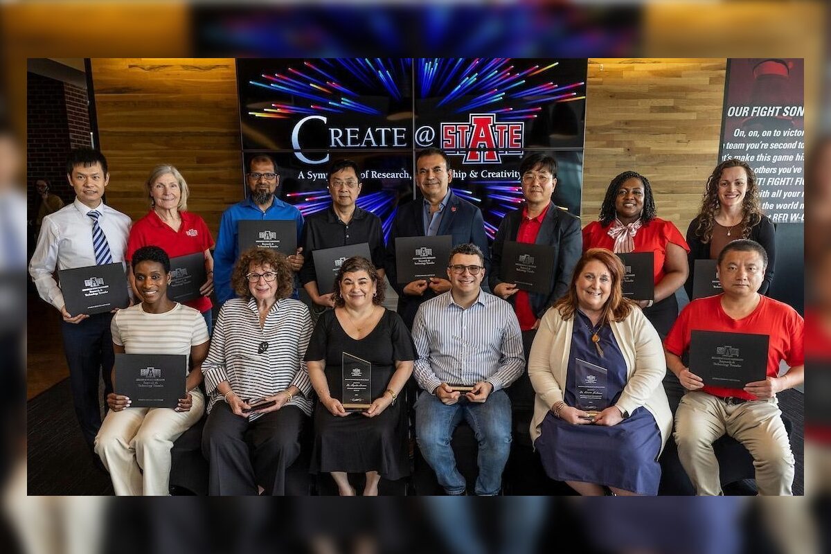 Group of diverse people posing with awards/plaques at a ceremony, banner reads 'Create @ State' in the background.
