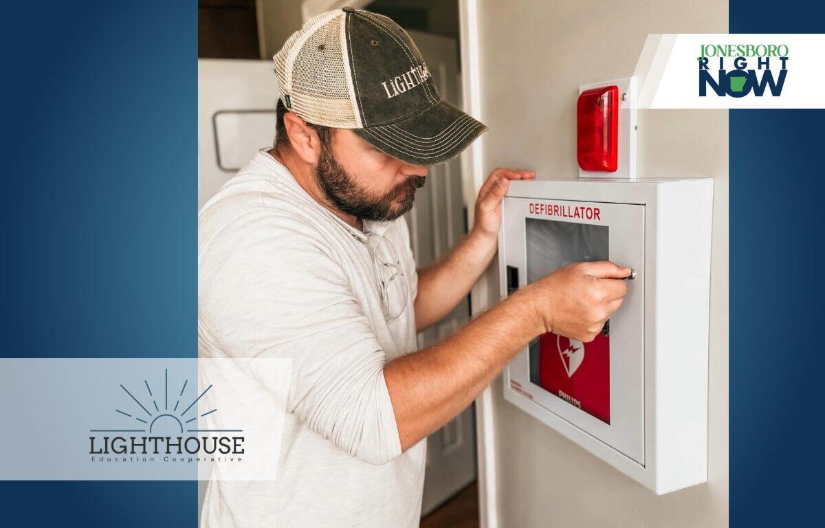 Man installing AED at school
