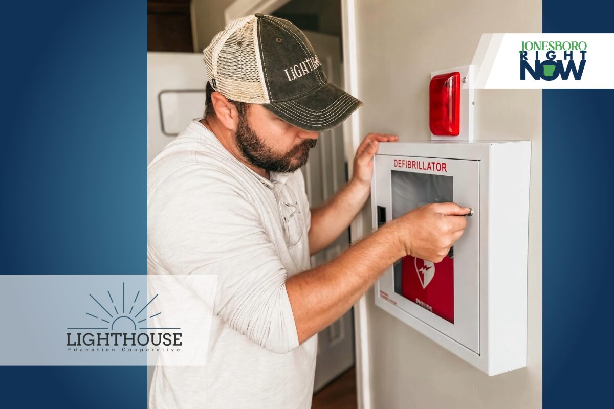 Man installing AED at school