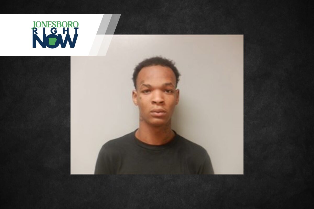 Mugshot-style photo of a young man facing the camera in a dark shirt against a light gray background, with a Jonesboro Right Now banner in the corner.