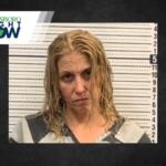 Mugshot of a woman with wet blond hair in a gray and black striped jumpsuit, standing against a height chart; Jonesboro Right Now logo in corner.
