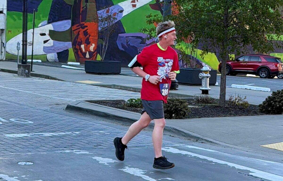 teenage boy runs through streets in running gear