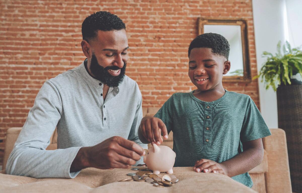 father and son putting pennies in piggy bank