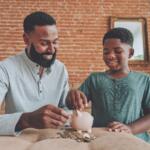 father and son putting pennies in piggy bank