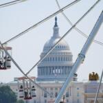 Ferris wheel with red cabins in the foreground and the U.S. Capitol building in Washington, D.C., in the background.