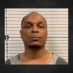 Mugshot of a man facing the camera in front of a height-measurement wall.