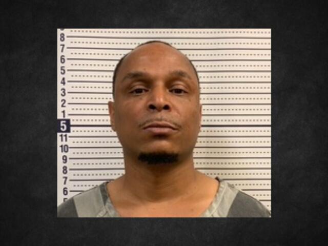 Mugshot of a man facing the camera in front of a height-measurement wall.