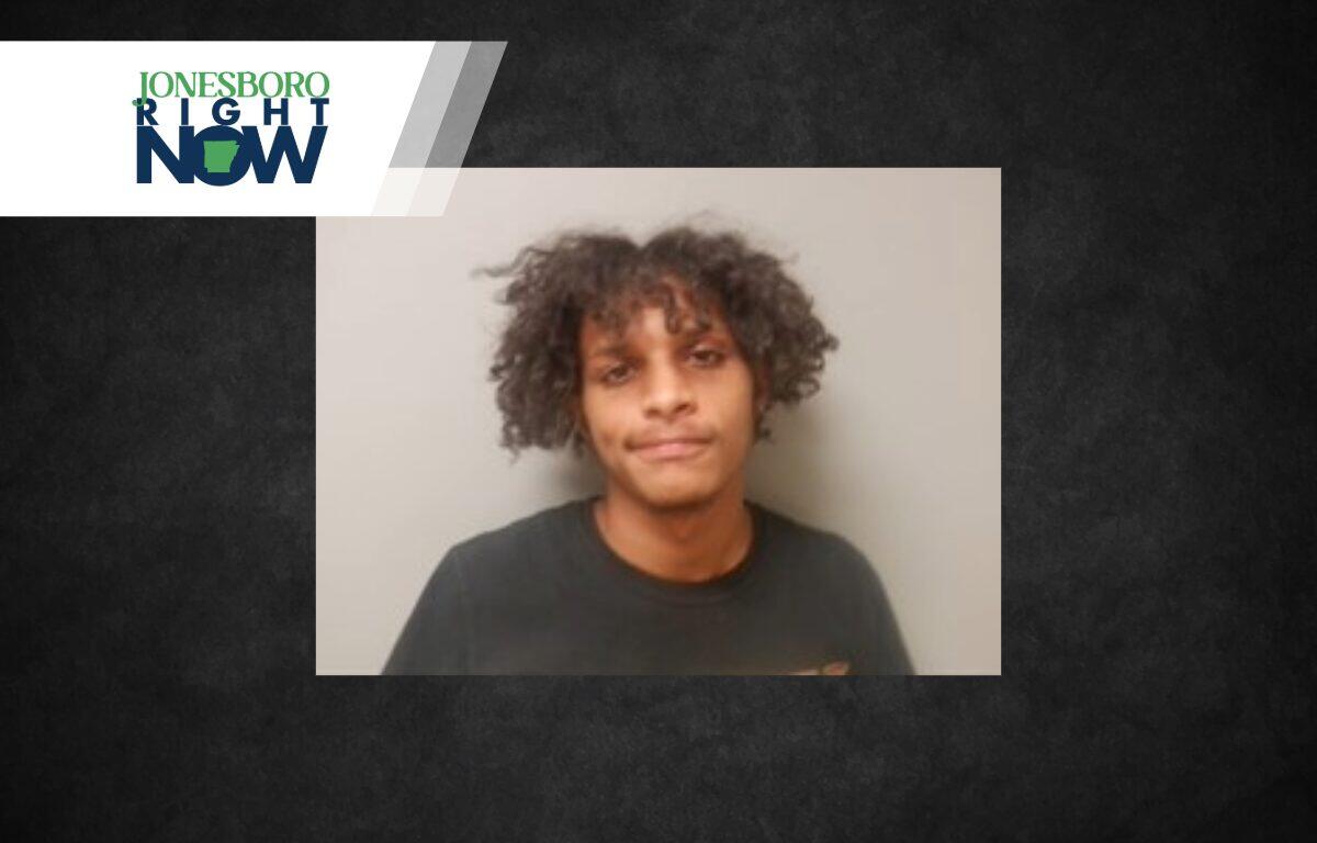 Young man with curly hair wearing a black shirt against a gray wall; Jonesboro Right Now banner in the top-left corner.