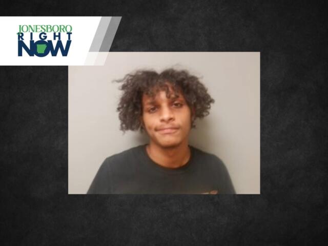 Young man with curly hair wearing a black shirt against a gray wall; Jonesboro Right Now banner in the top-left corner.